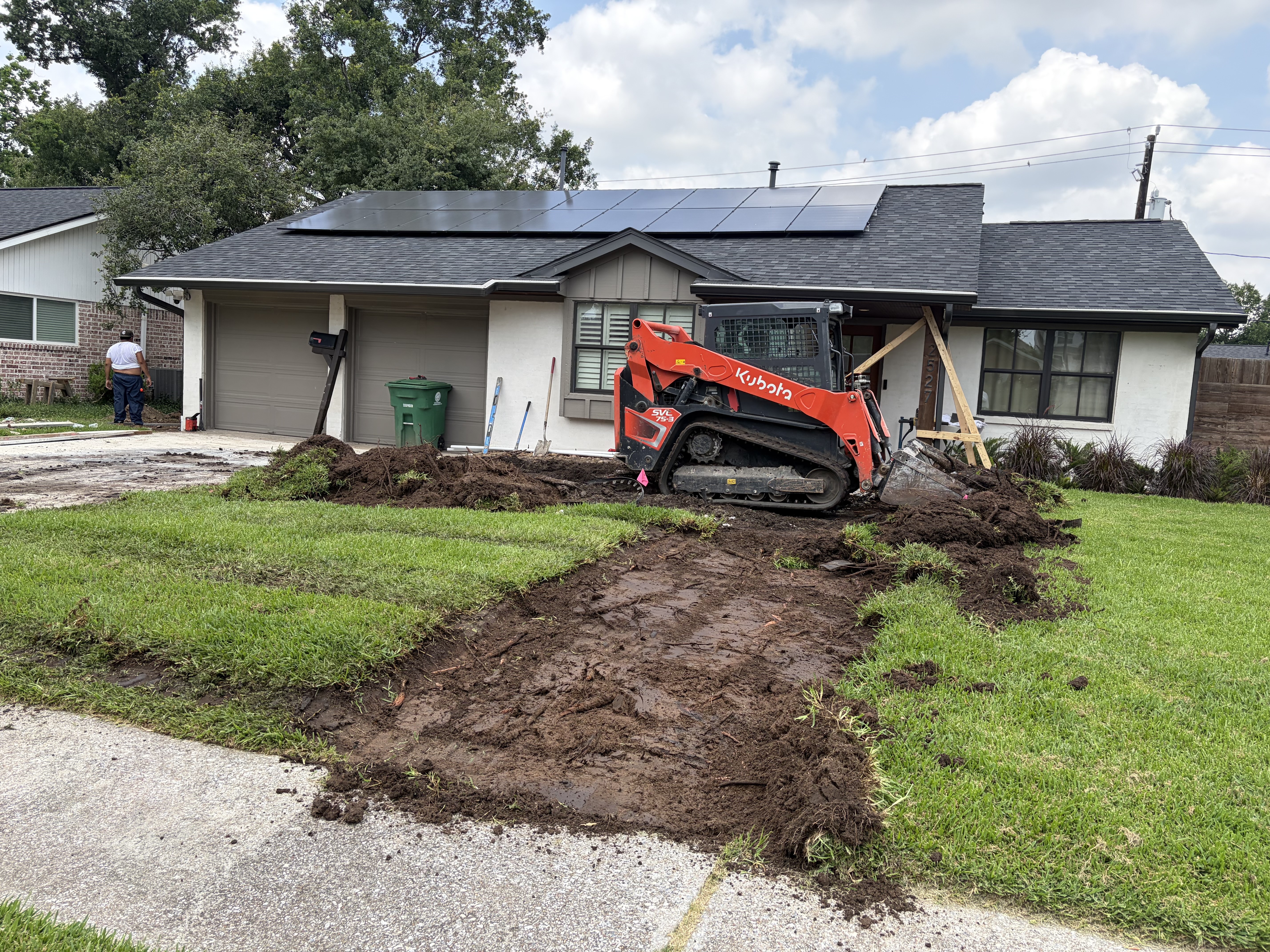 Construction process removing old tree roots before new concrete walkway installation in Houston Heights