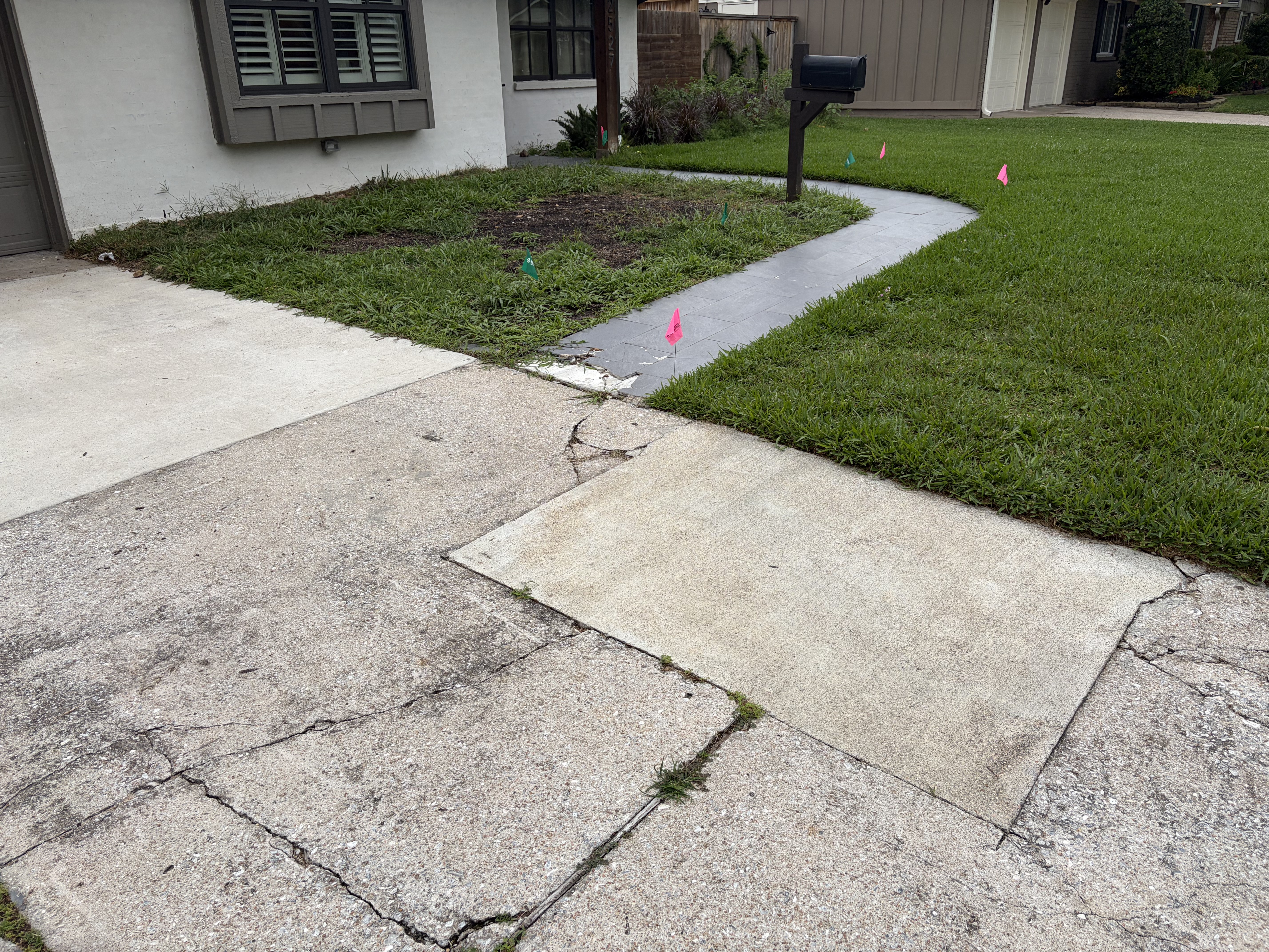 Settled and cracked concrete slab in Houston Texas showing section noticeably lower than surrounding surface