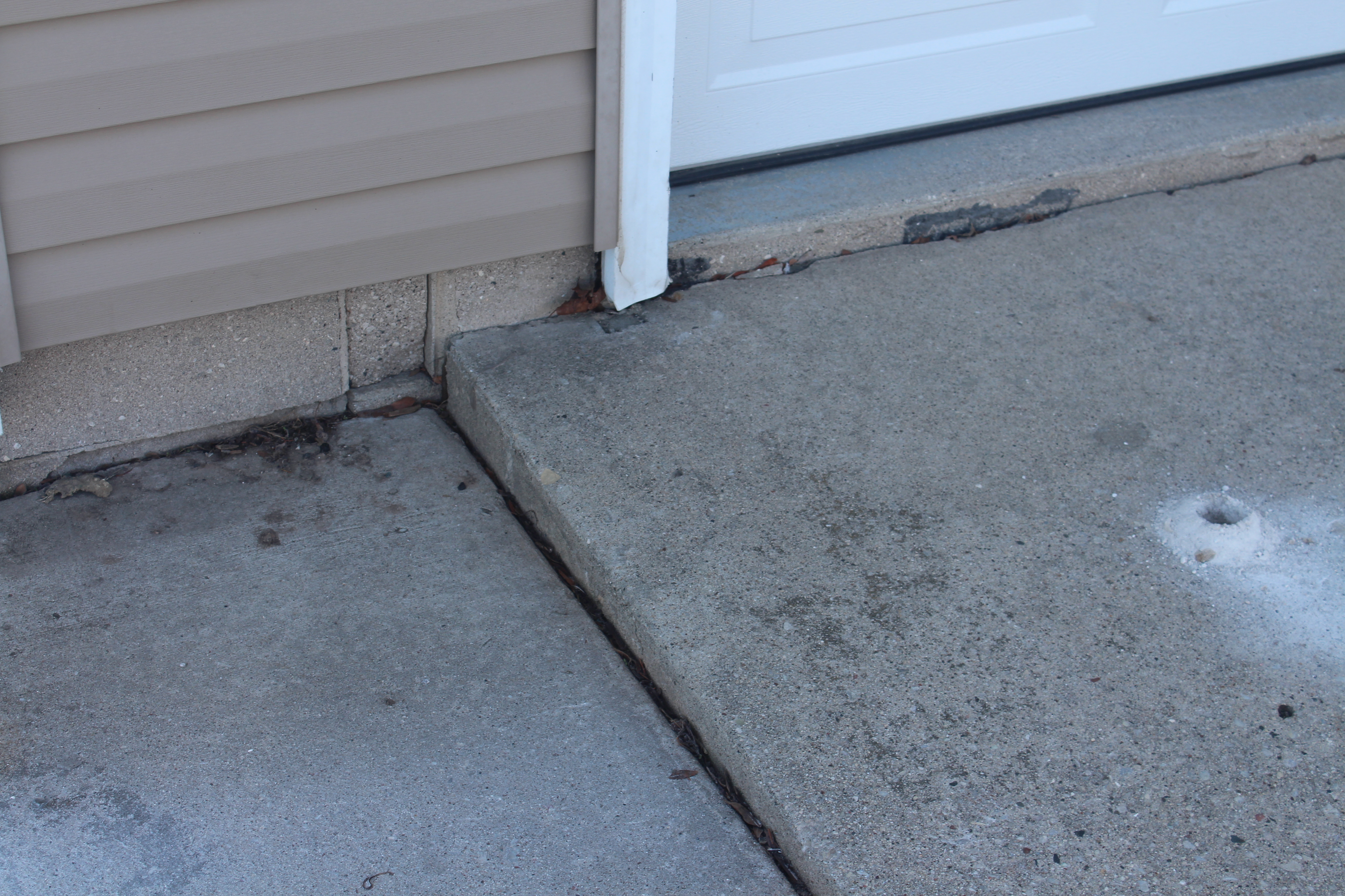 sunken uneven concrete pad slab before leveling repair Houston TX